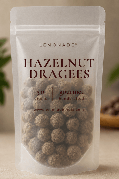 Gourmet hazelnut dragées in premium packaging, featuring whole roasted hazelnuts coated in smooth milk chocolate
