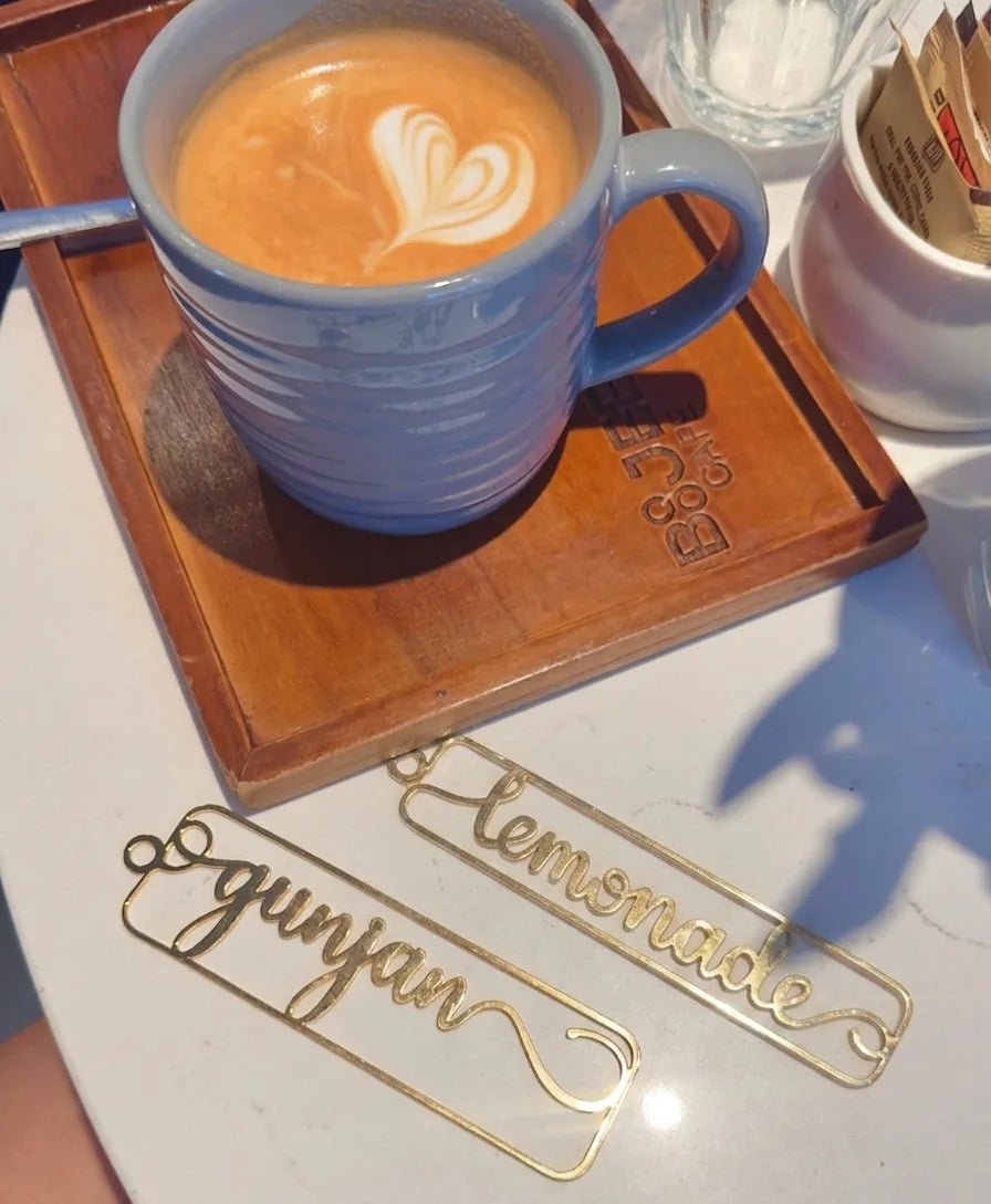 A top-down aesthetic view of premium gold-toned metallic wire script page markers