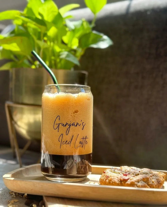Custom engraved can glass filled with iced coffee and milk swirl detail