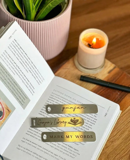 A flat lay view of three sleek silver metallic bookmarks with customized typography