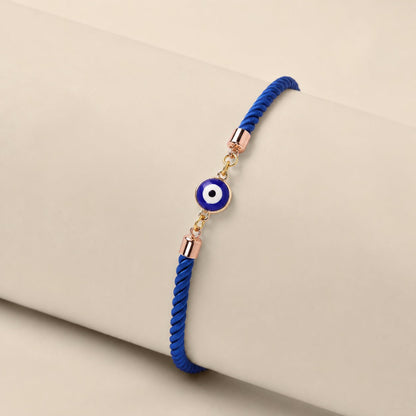 Mini Evil Eye Rakhi with a blue evil eye charm on a braided blue and white thread, handcrafted for Raksha Bandhan gifting