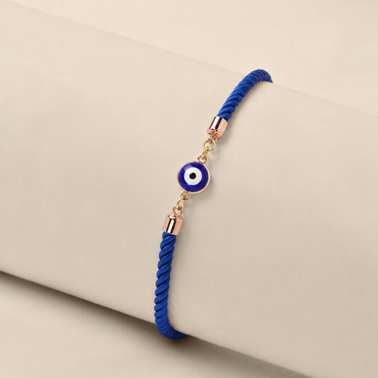 Mini Evil Eye Rakhi with a blue evil eye charm on a braided blue and white thread, handcrafted for Raksha Bandhan gifting