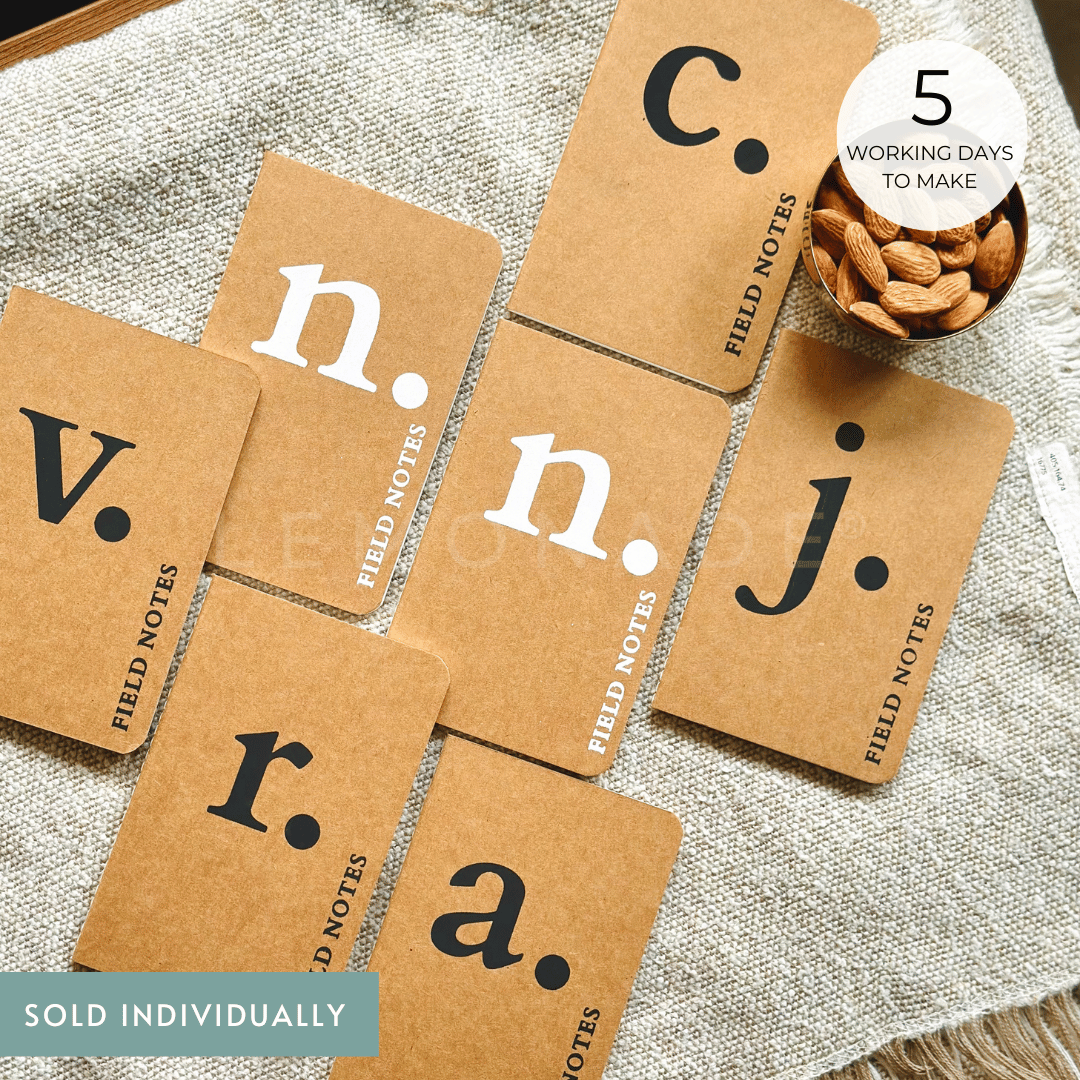 A minimalist custom monogram kraft notebook featuring a simple typography layout on a brown pocket-size cover
